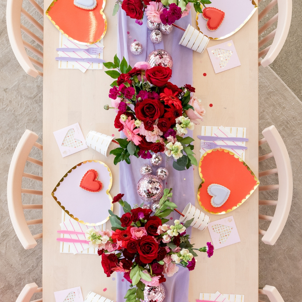 Red and lilac gold rimmed large dinner plates heart shaped decor for romantic theme from Parte Haus party supply store in Bethesda MD