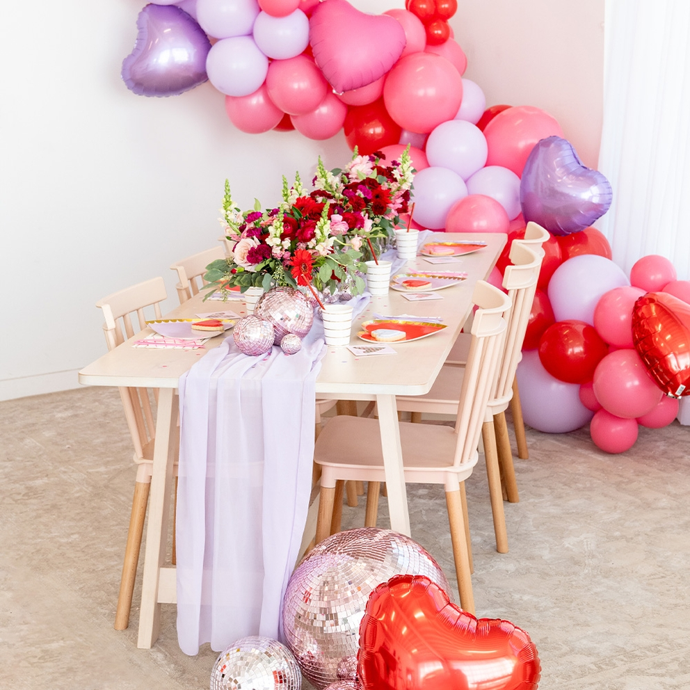 Red and lilac gold rimmed large dinner plates on Valentine themed table from Parte Haus party supply store in Bethesda MD
