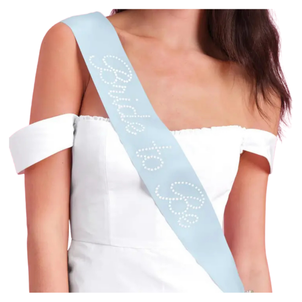 Light blue bride to be sash with white rhinestone letters for bridal shower from Parte Haus party supply store in Bethesda MD