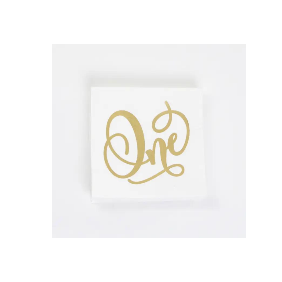 Gold and white napkin with One script for first birthday from Parte Haus party supply store in Bethesda MD