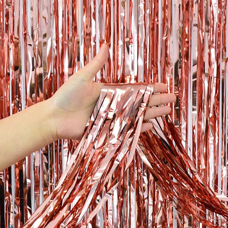 Rose gold fringe tinsel curtain backdrop held by hand celebration decor from Parte Haus party supply store in Bethesda MD