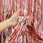 Rose gold fringe tinsel curtain backdrop held by hand celebration decor from Parte Haus party supply store in Bethesda MD