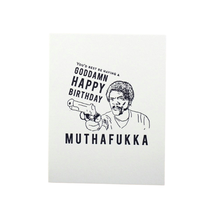 White birthday card with cartoon man holding a gun and bold text from Parte Haus party supply store in Bethesda MD