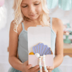 Purple shell-shaped cookie favor box mermaid birthday theme from Parte Haus party supply store in Bethesda MD
