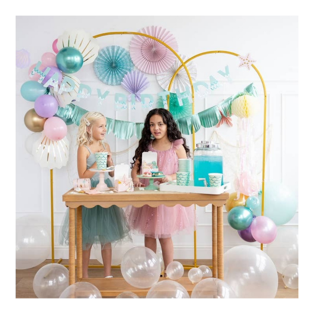 Pastel mermaid birthday decorations and dessert table with balloons and girls from Parte Haus party supply store in Bethesda MD