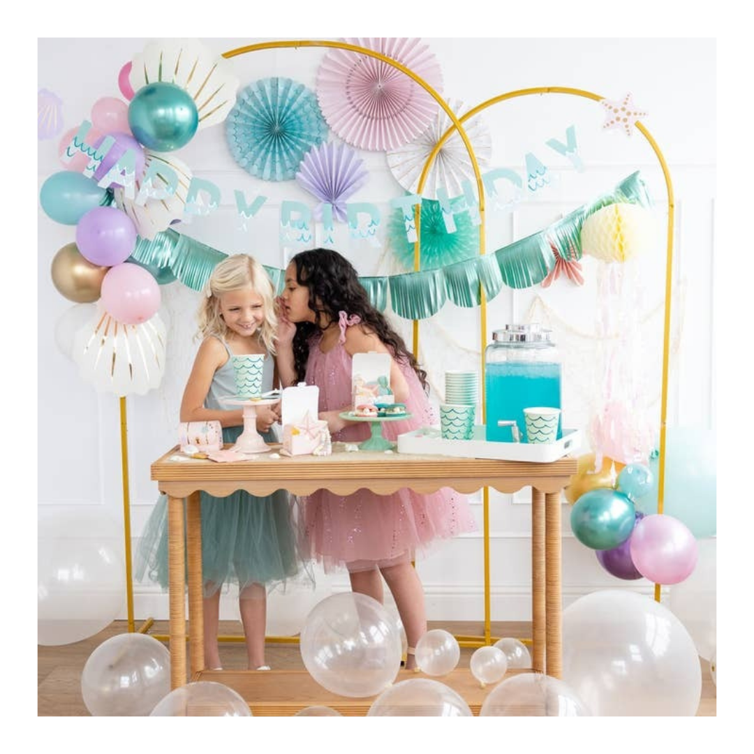 Teal and pink mermaid birthday party setup with paper fans pastel balloons and two girls from Parte Haus party supply store in Bethesda MD
