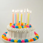 Pastel rainbow gradient candle set on birthday cake for celebration from Parte Haus party supply store in Bethesda Maryland