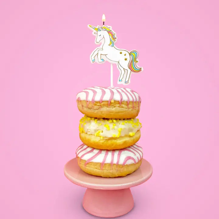 White unicorn cake topper candle on pink and yellow donuts for birthday from Parte Haus party supply store in Bethesda MD