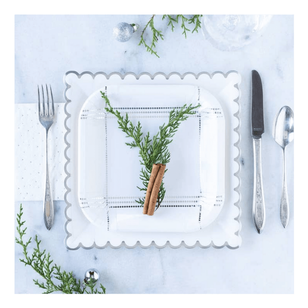 White scalloped paper plate with greenery and cinnamon stick holiday setting from Parte Haus party supply store in Bethesda MD
