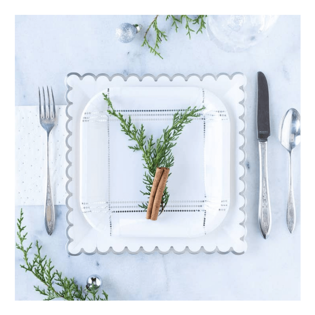 White scalloped paper plate with greenery and cinnamon stick holiday setting from Parte Haus party supply store in Bethesda MD