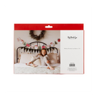 red Whimsy Christmas banner with Santa and tree icons holiday decor above bed from Parte Haus party supply store in Bethesda Maryland