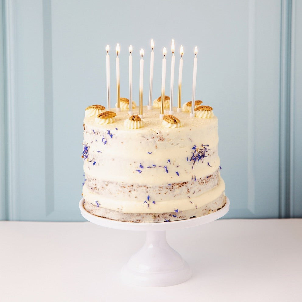 White and silver birthday candles on frosted cake birthday from Parte Haus party supply store in Bethesda Maryland