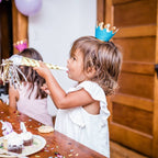 Blue crown headband girl with gold party blower at kids birthday from Parte Haus party supply store in Bethesda Maryland