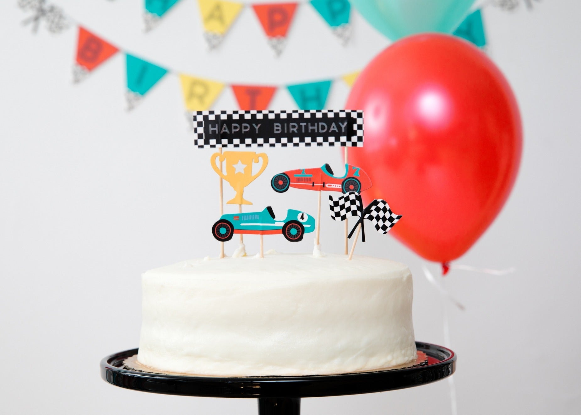 White race car birthday cake with trophy and car toppers racing birthday theme from Parte Haus party supply store in Bethesda Maryland