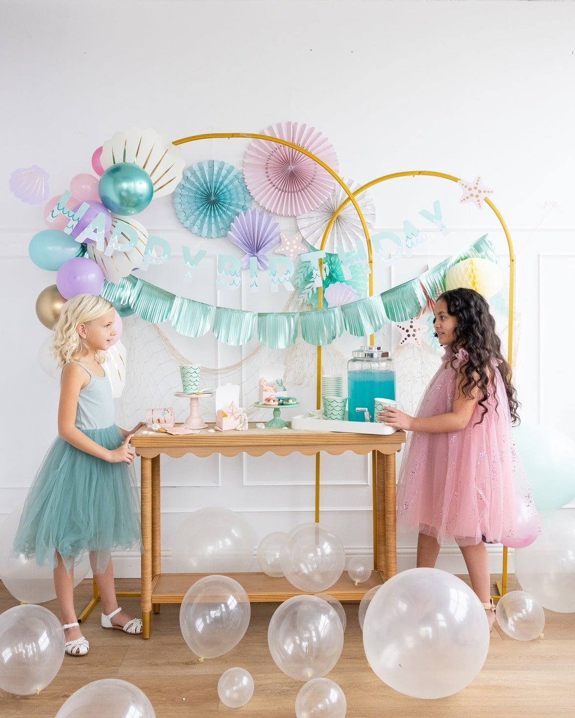 Pastel birthday decorations with balloons and girls in dresses mermaid birthday theme from Parte Haus party supply store in Bethesda Maryland
