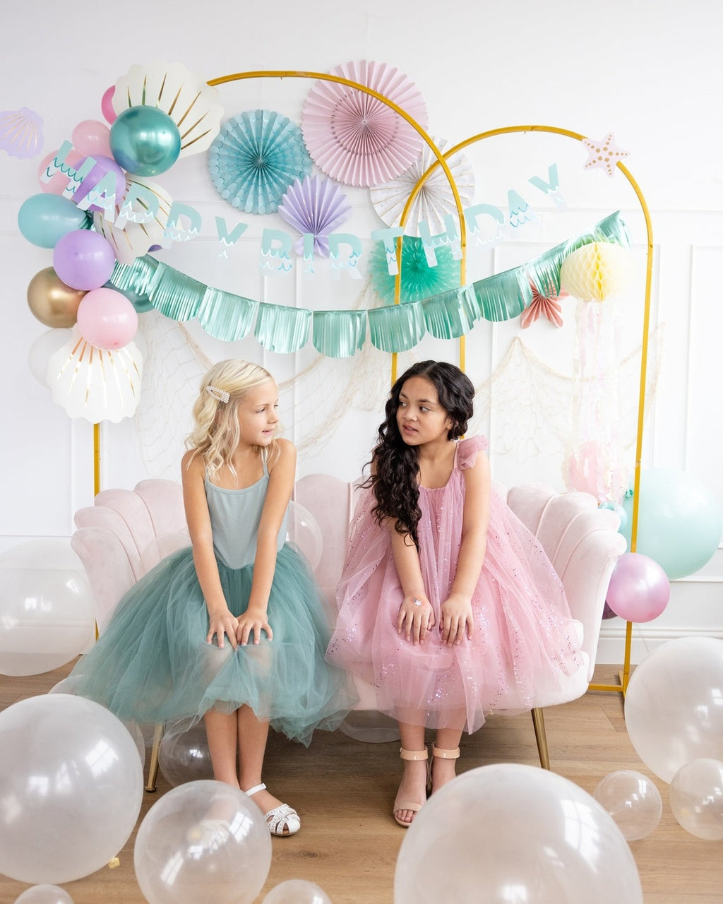 Pink pastel birthday backdrop with balloons and two girls from Parte Haus party supply store in Bethesda Maryland