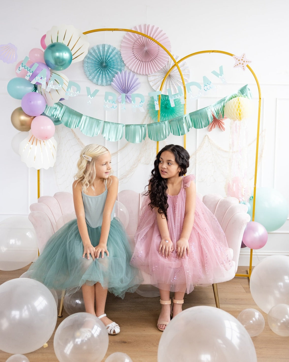 Pink pastel birthday backdrop with balloons and two girls from Parte Haus party supply store in Bethesda Maryland