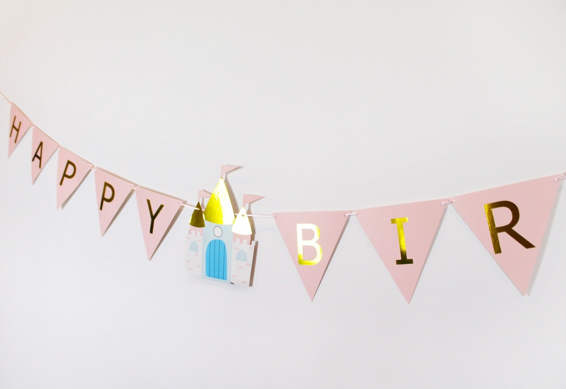 Pink princess birthday banner with gold letters and castle theme from Parte Haus party supply store in Bethesda Maryland