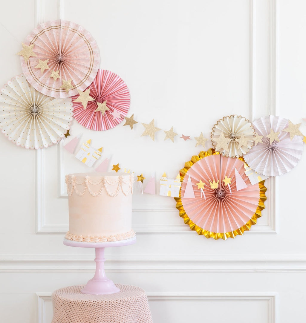 Pink and gold cake with pastel paper fans and star garland princess birthday from Parte Haus party supply store in Bethesda MD