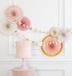 Pink and gold cake with pastel paper fans and star garland princess birthday from Parte Haus party supply store in Bethesda MD