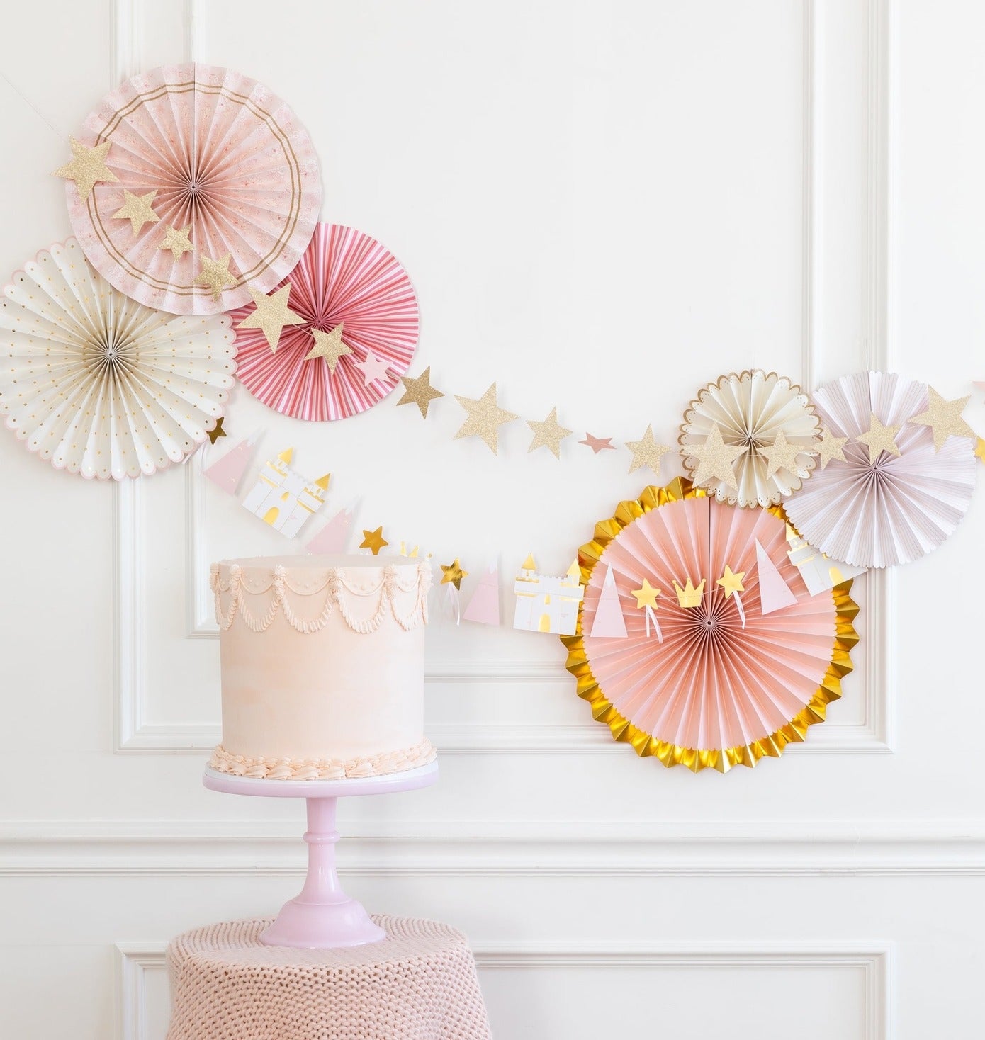Pink and gold cake with pastel paper fans and star garland princess birthday from Parte Haus party supply store in Bethesda MD