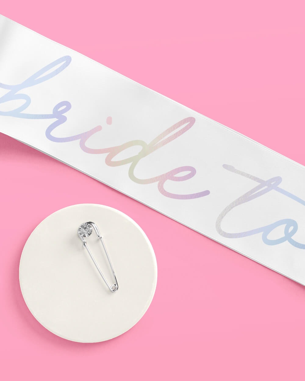 White iridescent bride sash with safety pin for bridal shower from Parte Haus party supply store in Bethesda MD