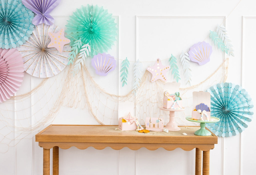 Pastel mermaid birthday decorations with seashell banners and table decor from Parte Haus party supply store in Bethesda MD