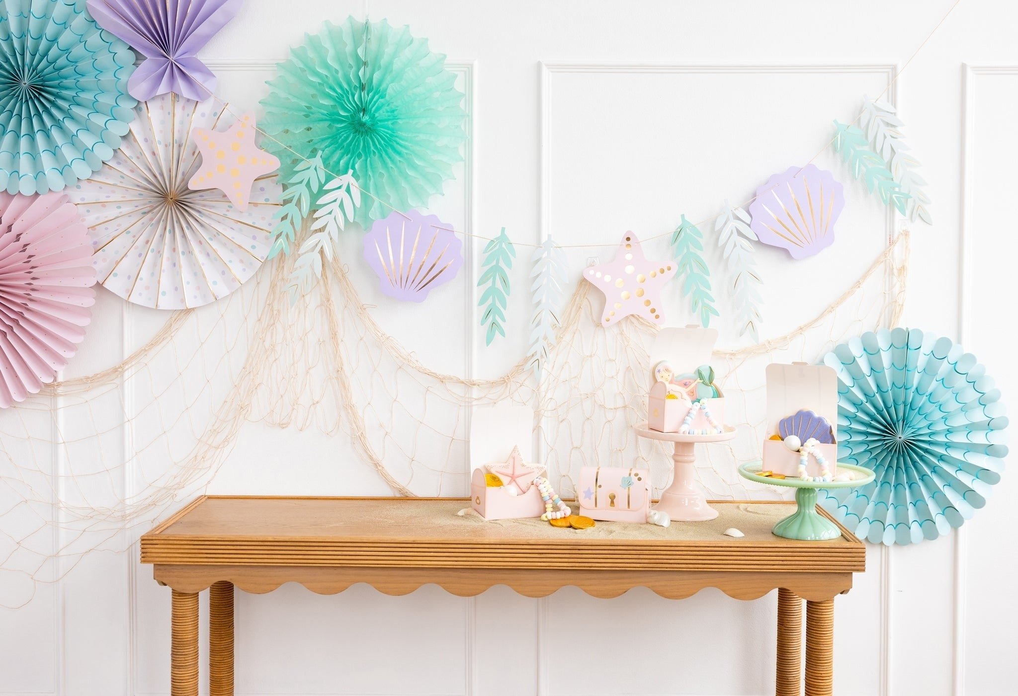 Pastel mermaid birthday decorations with seashell banners and table decor from Parte Haus party supply store in Bethesda MD