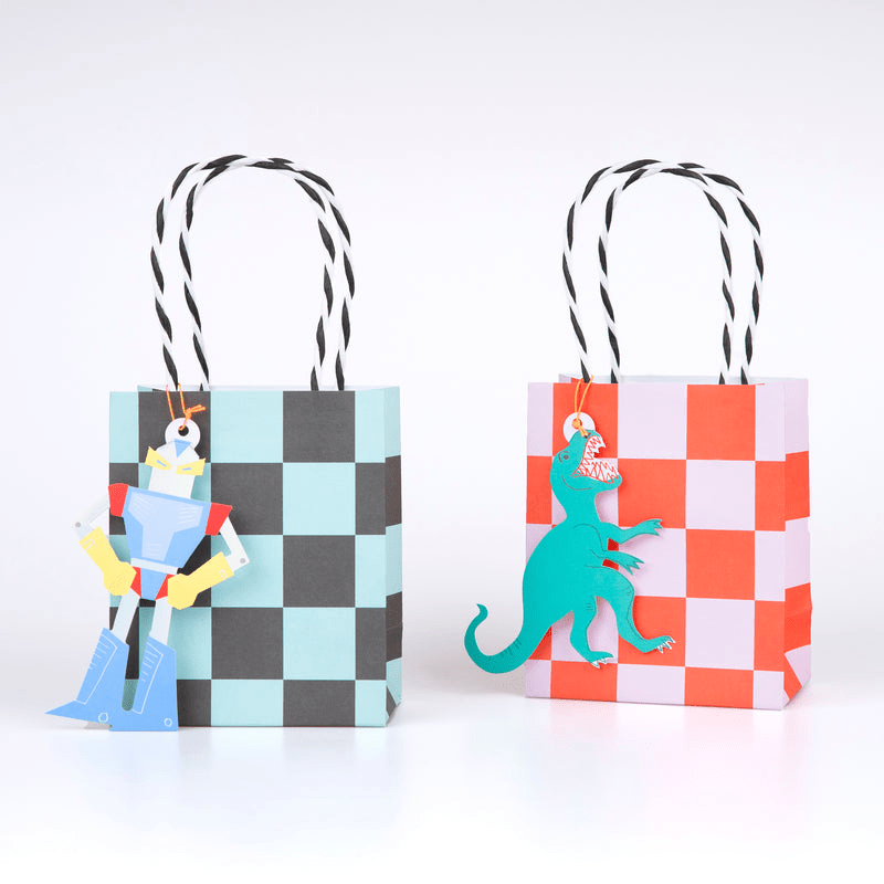 Blue checkerboard gift bag with robot tag and red checkerboard gift bag with dinosaur tag birthday theme from Parte Haus party supply store in Bethesda Maryland
