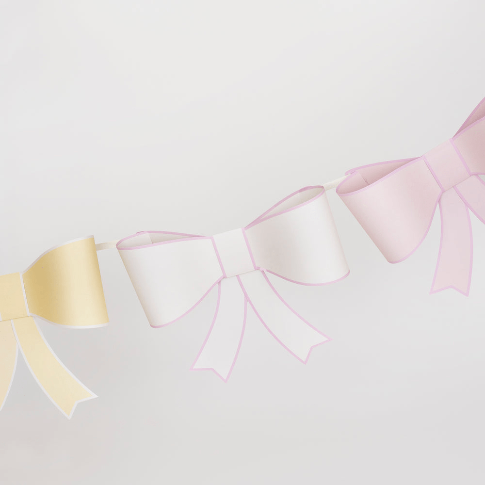 Pastel yellow white and pink bow garland banner for birthday or celebration from Parte Haus party supply store in Bethesda Maryland