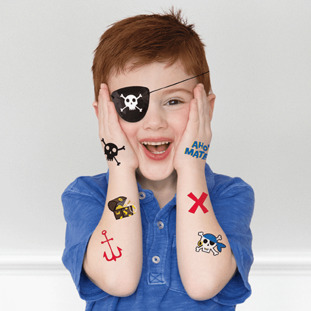 Black pirate tattoos on smiling child with pirate eye patch for pirate birthday theme from Parte Haus party supply store in Bethesda MD.