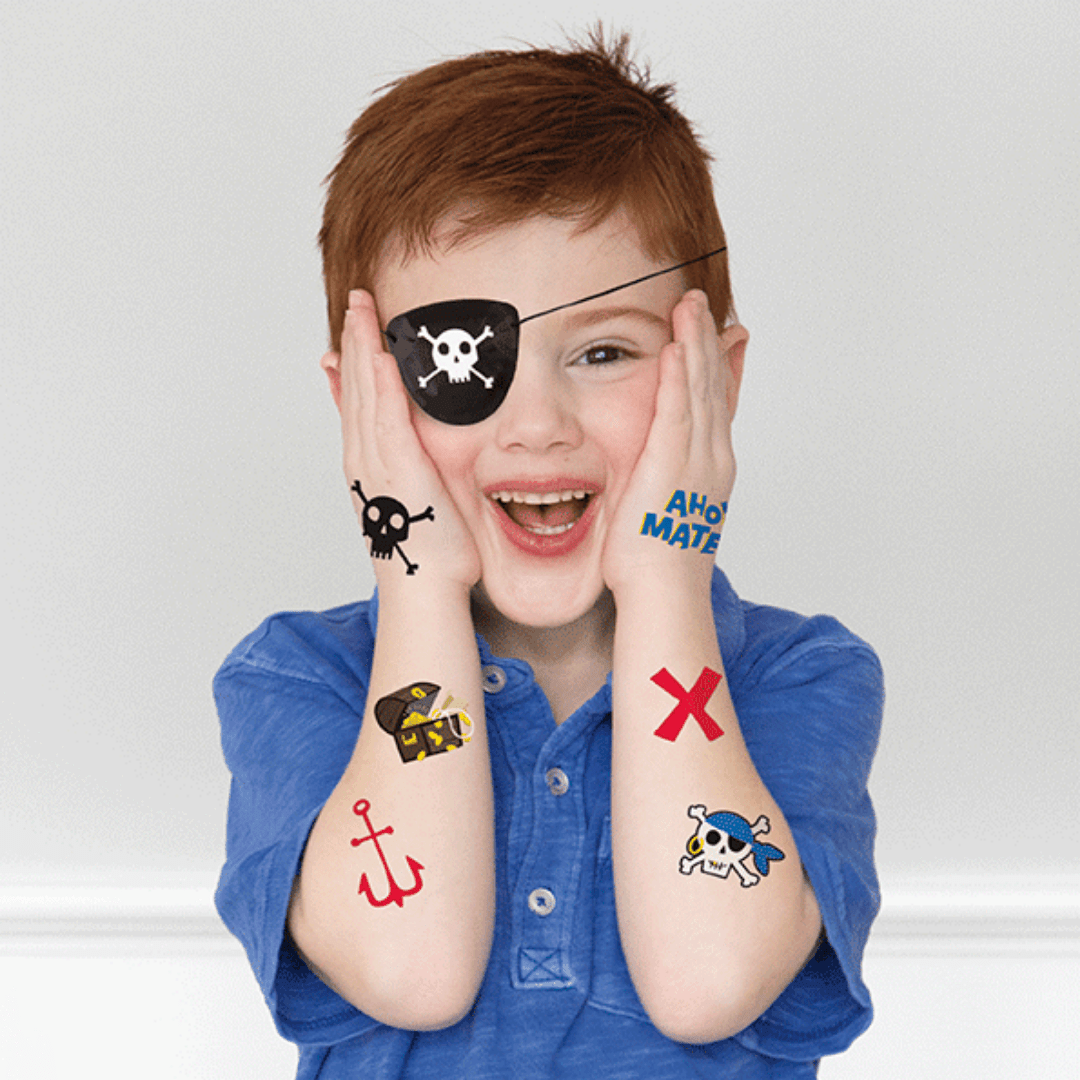 Black pirate tattoos on smiling child with pirate eye patch for pirate birthday theme from Parte Haus party supply store in Bethesda MD.