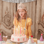 Pink birthday cake with tall candles and a girl in yellow dress for birthday theme from Parte Haus party supply store in Bethesda MD