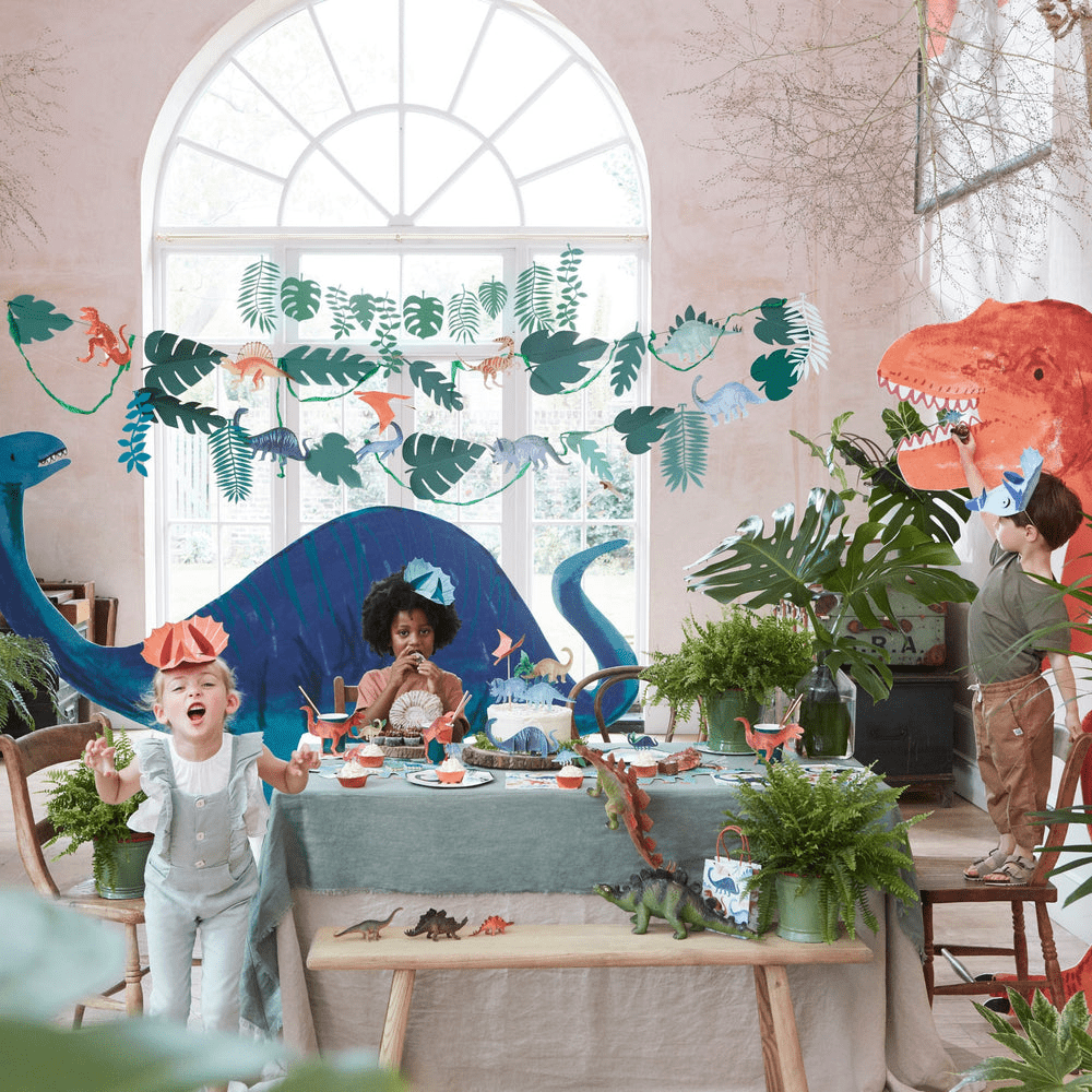 Colorful dinosaur themed birthday table decor with kids from Parte Haus party supply store in Bethesda MD