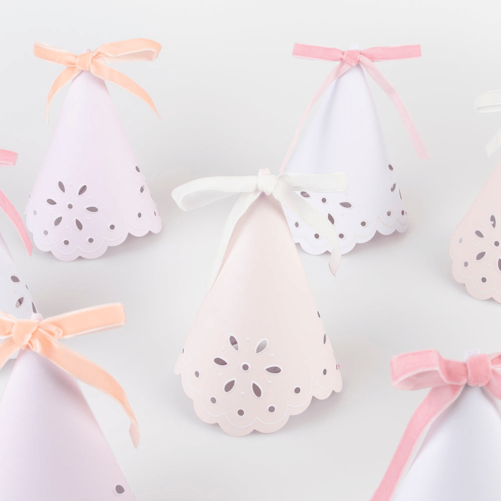 Pastel pink and white cone shaped party hats with ribbon bows birthday from Parte Haus party supply store in Bethesda MD.