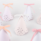 Pastel pink and white cone shaped party hats with ribbon bows birthday from Parte Haus party supply store in Bethesda MD.