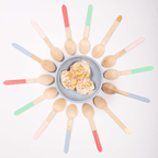 Color dipped wooden ice cream spoons arranged around a blue bowl dessert birthday from Parte Haus party supply store in Bethesda Maryland