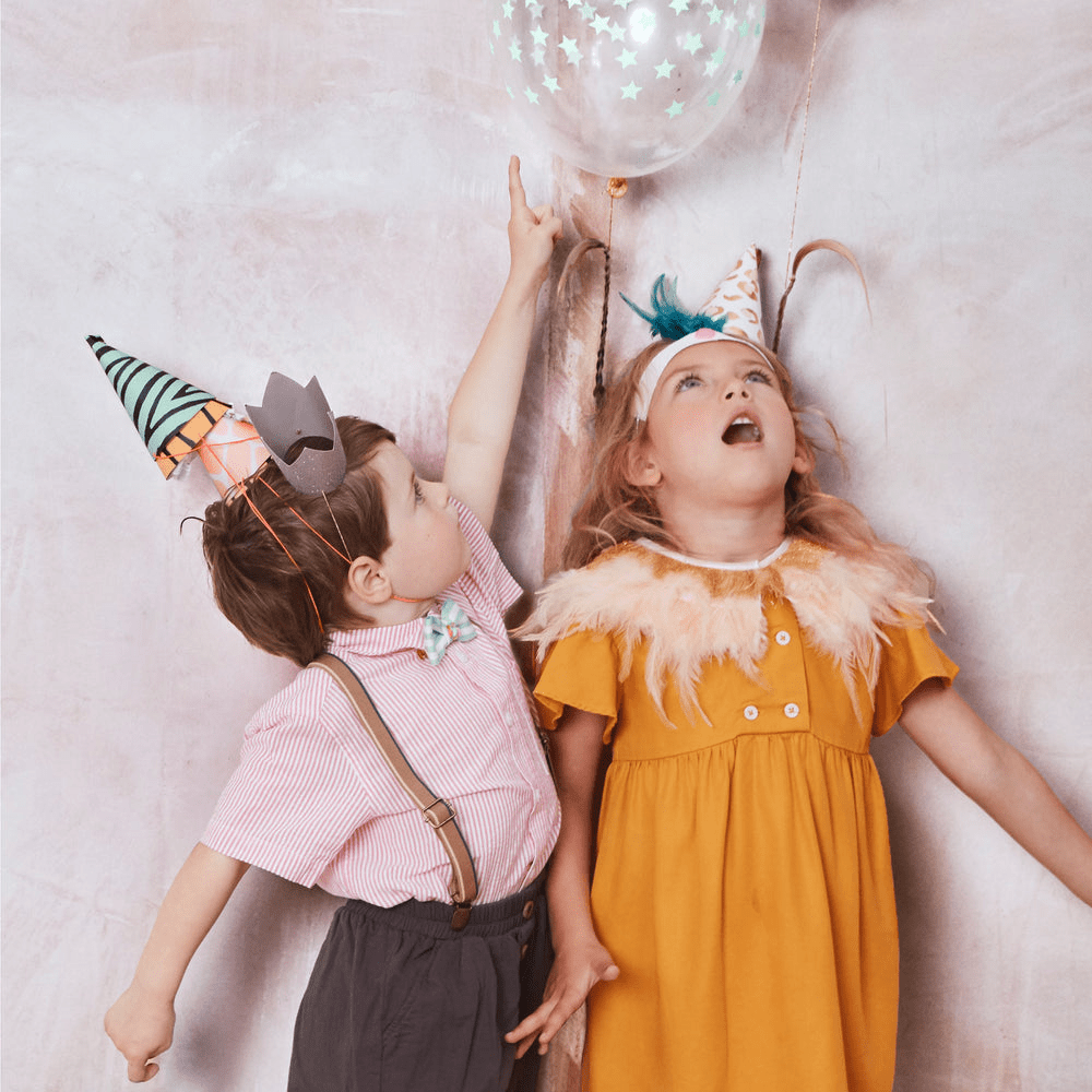 Colorful birthday hats and balloon with stars kids in festive attire celebration theme from Parte Haus party supply store in Bethesda Maryland