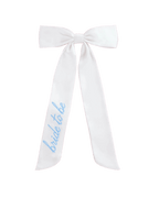 White bow hair accessory with blue bride to be text for bridal shower from Parte Haus party supply store in Bethesda Maryland