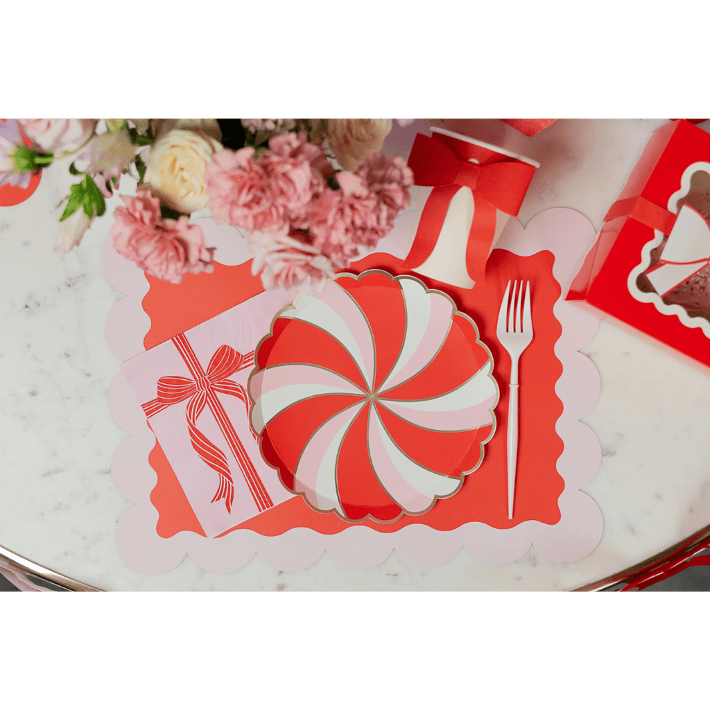 Red and pink peppermint swirl plate with scalloped placemat holiday table decor from Parte Haus party supply store in Bethesda MD