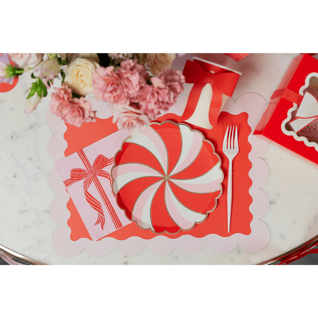 Red and pink peppermint swirl plate with scalloped placemat holiday table decor from Parte Haus party supply store in Bethesda MD