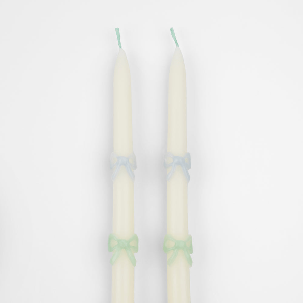 Ivory taper candles with pastel blue and green bows birthday decor from Parte Haus party supply store in Bethesda MD