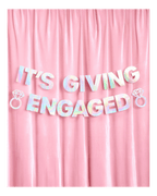 Iridescent engagement banner with diamond ring accents on pink backdrop engagement from Parte Haus party supply store in Bethesda Maryland