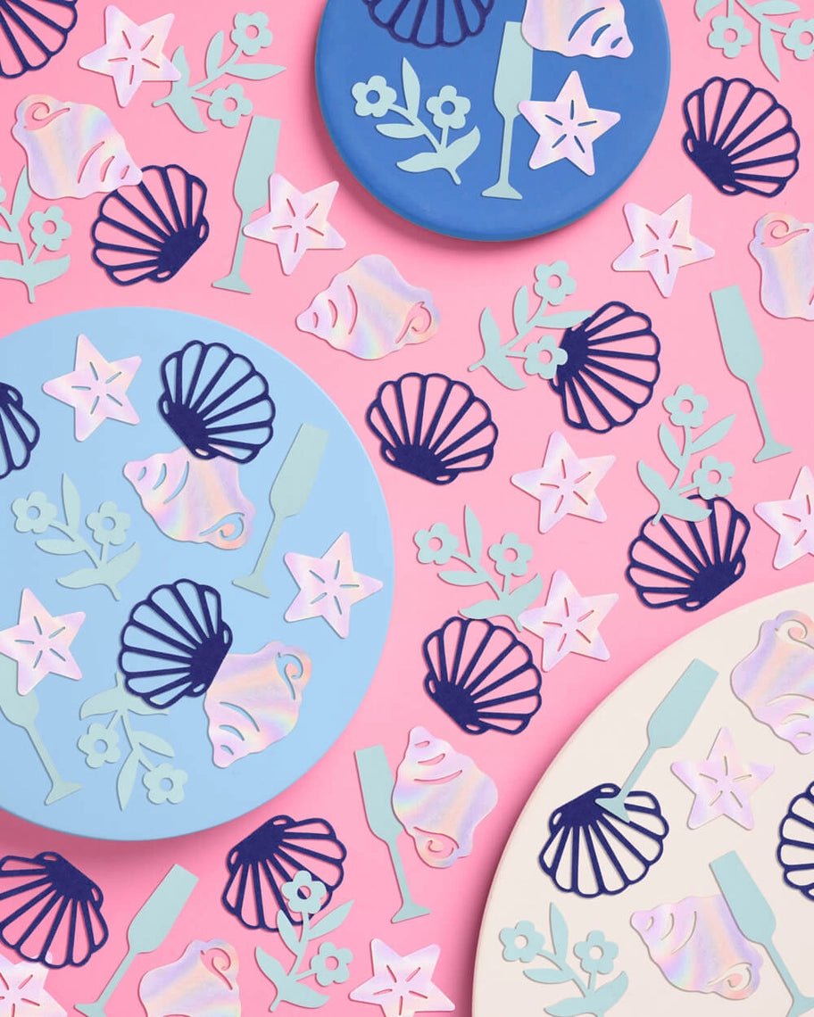 Pastel blue and pink beach themed confetti with seashell starfish and champagne designs summer celebration from Parte Haus party supply store in Bethesda Maryland