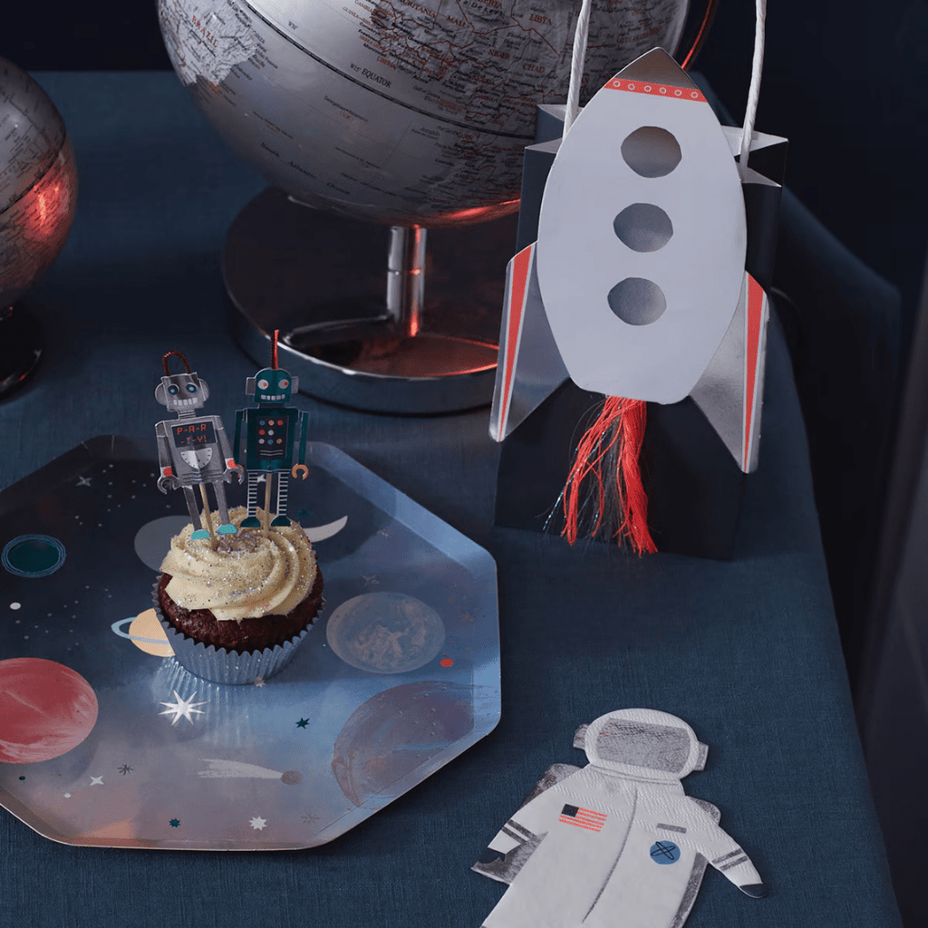 Silver and blue robot cupcake toppers and rocket themed treat bag for space birthday from Parte Haus party supply store in Bethesda MD
