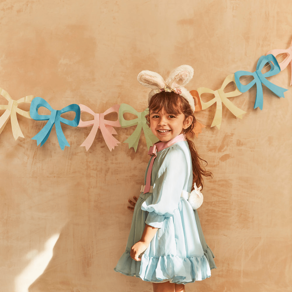 Pastel easter garland with bows and smiling girl with bunny ears Easter theme from Parte Haus party supply store in Bethesda MD