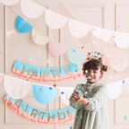 Pastel birthday banner and garlands with confetti and smiling child birthday theme from Parte Haus party supply store in Bethesda MD