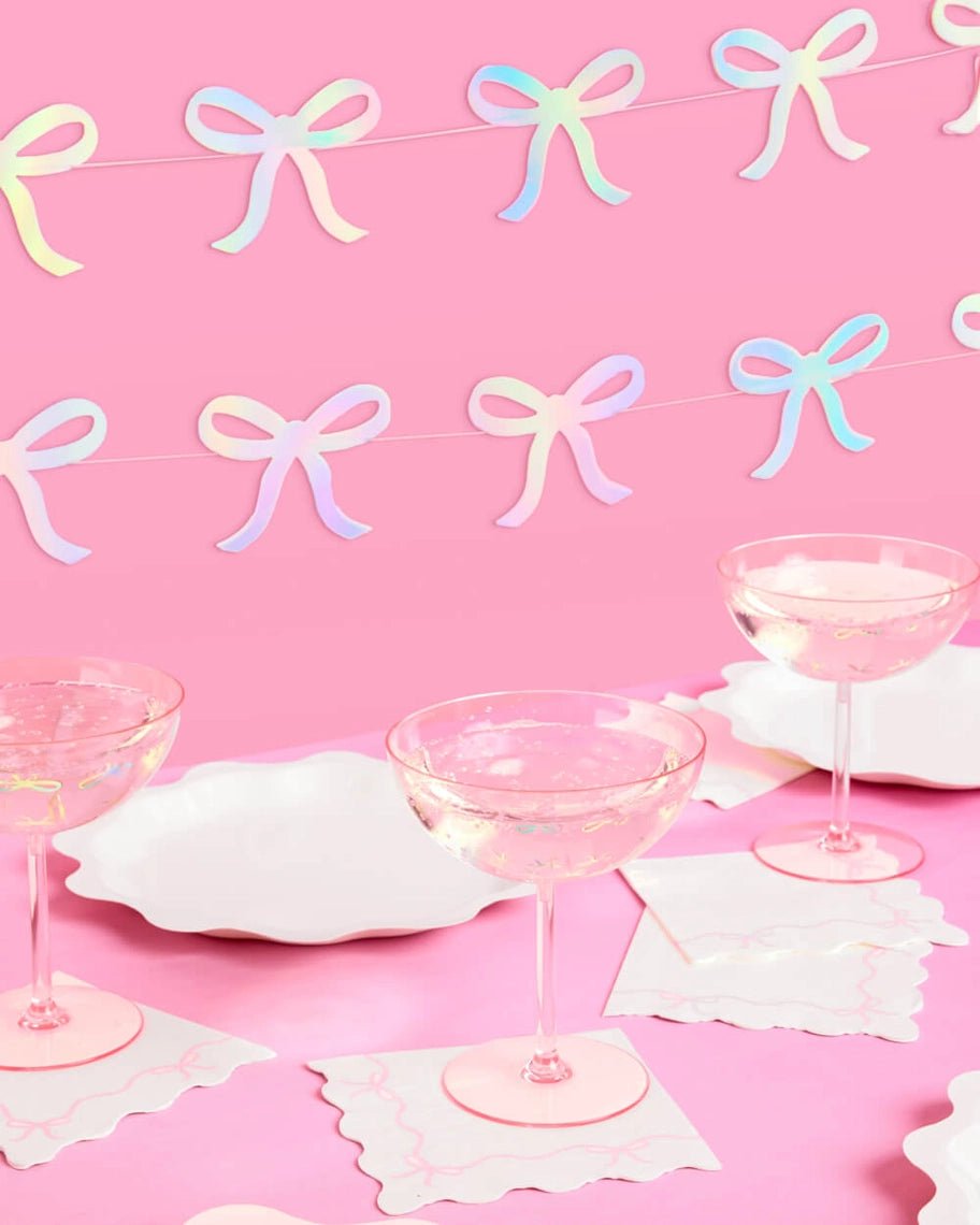 Iridescent pink bow garland with matching tableware and drinks birthday theme from Parte Haus party supply store in Bethesda MD