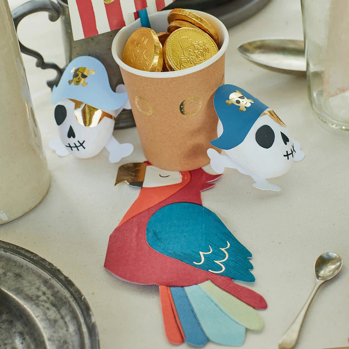Blue pirate skull decorations gold coins and red parrot napkin pirate birthday theme from Parte Haus party supply store in Bethesda Maryland
