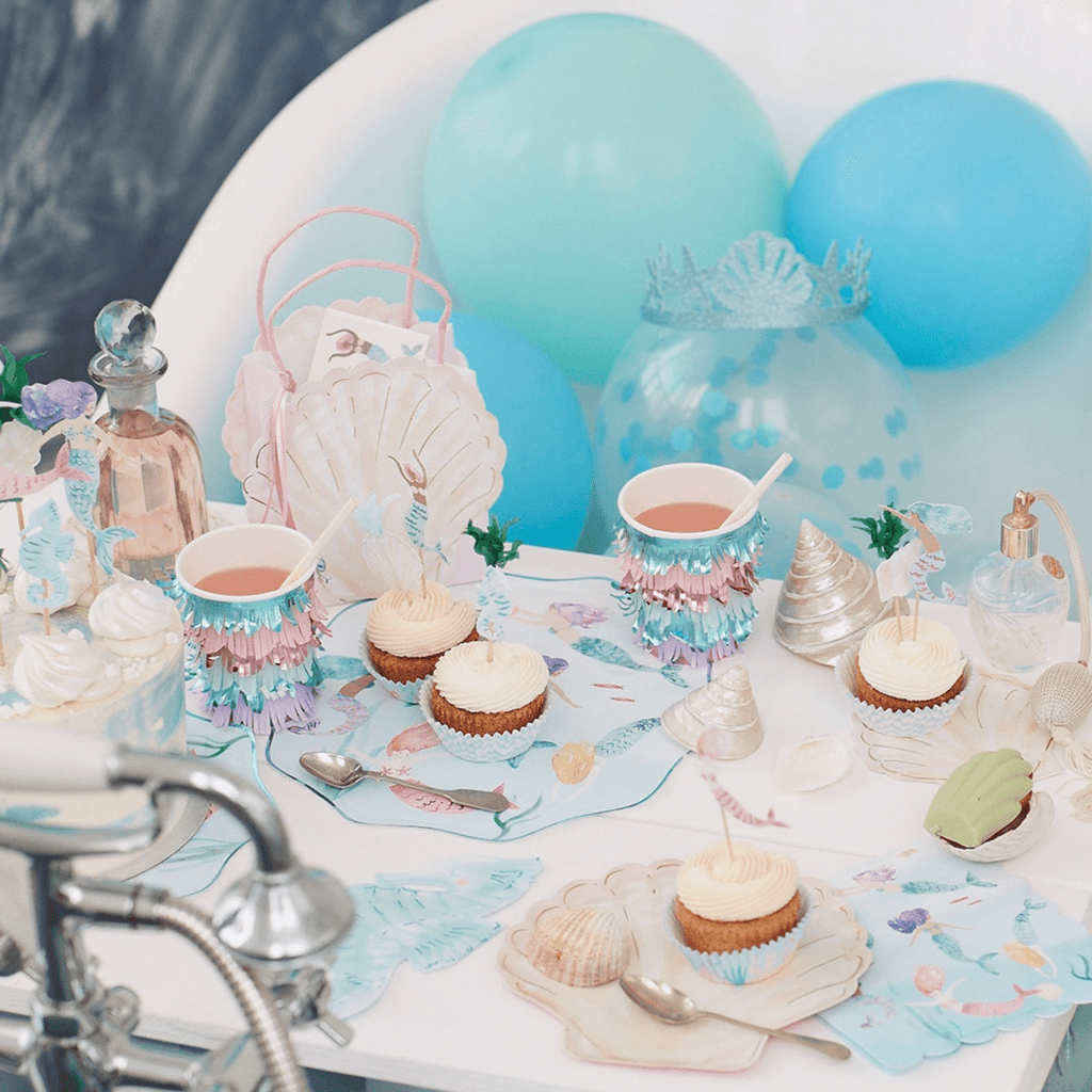 Pastel mermaid birthday table decor with cupcakes and blue balloons from Parte Haus party supply store in Bethesda Maryland